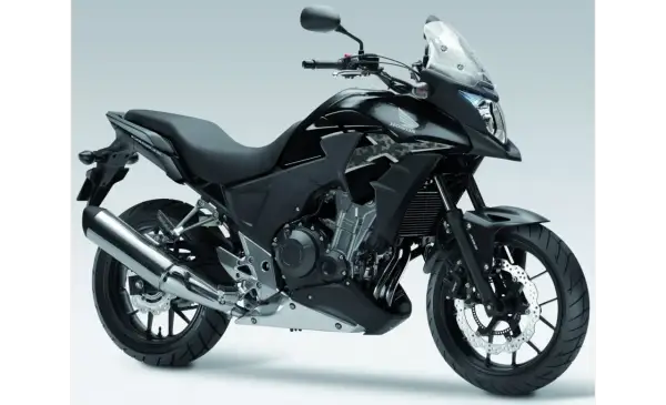 Czarny motocykl Honda CB500X z przyciemnianą szybą i chromowanym wydechem, gotowy na przygodę.