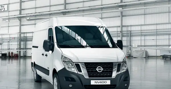 Biały van Nissan NV400 stoi w przestronnym magazynie.