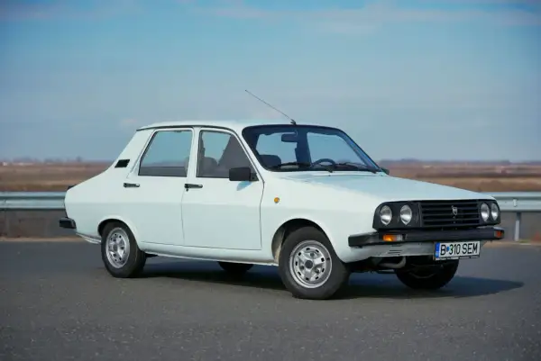 Biała Dacia 1300 na tle nieba i pól. Klasyk rumuńskiej motoryzacji gotowy na podróż.