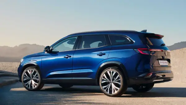 Błękitny Renault Espace 2024 z eleganckimi felgami stoi na tle pustynnego krajobrazu.
