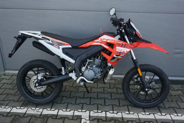 Pomarańczowy motocykl **senda** z białymi i czarnymi akcentami, gotowy do jazdy po mieście.
