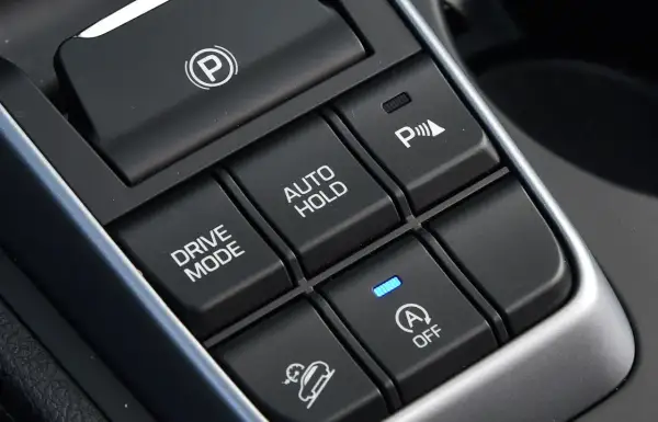 Przyciski w samochodzie: hamulec postojowy, Drive Mode, Auto Hold, asystent parkowania i system zapobiegający stoczeniu się na wzniesieniu (hill holder).