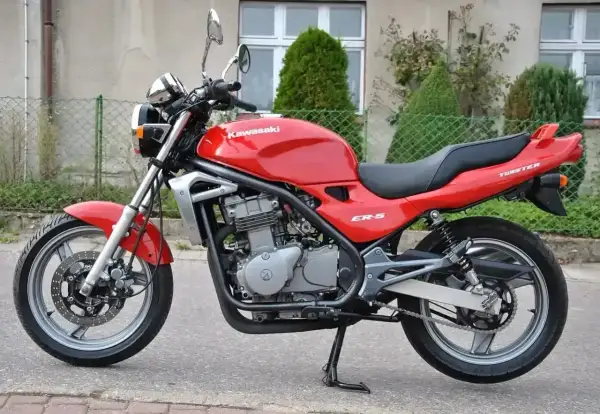Czerwony Kawasaki ER-5, gotowy do jazdy po miejskich ulicach. Klasyczny wygląd i niezawodność.